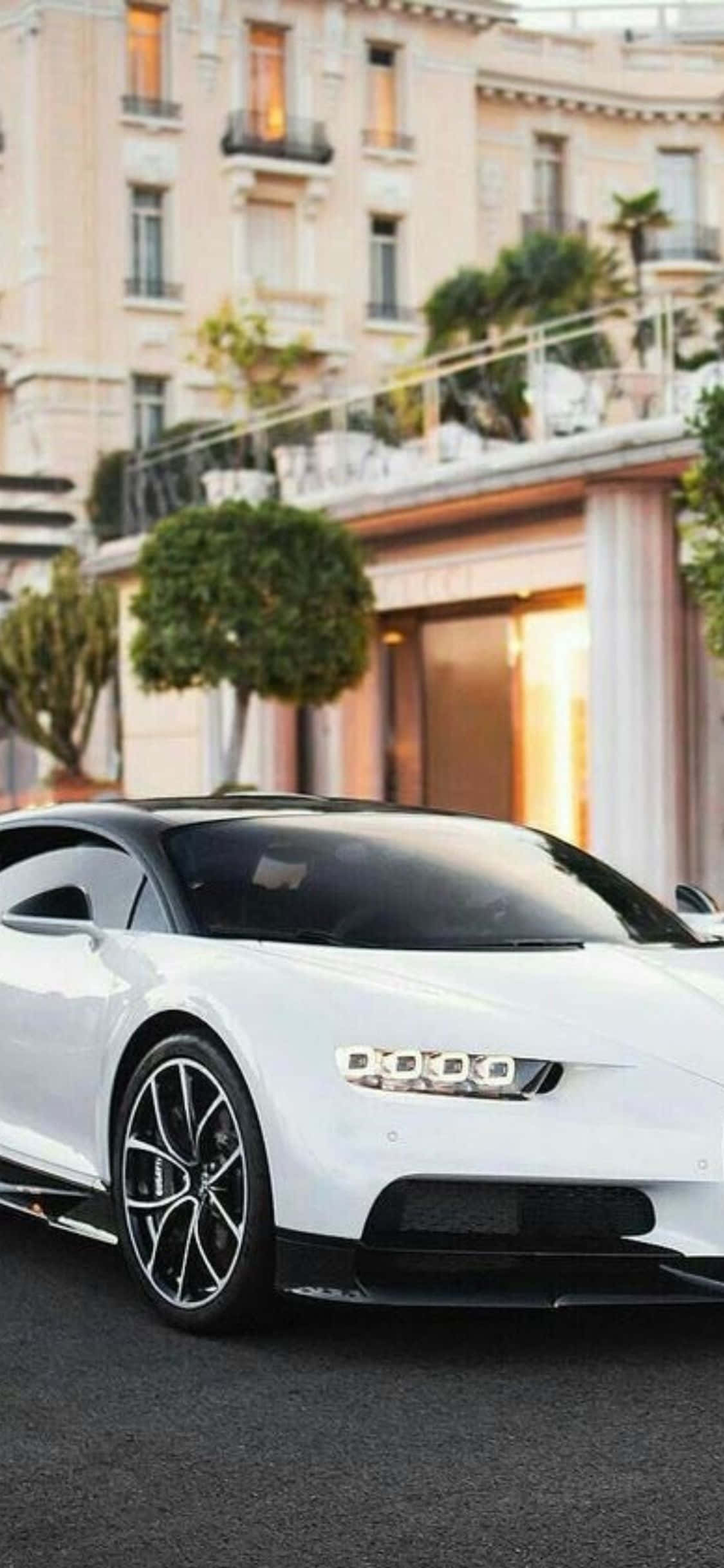 সাদা bugatti chiron একটি ভবনের সামনে পার্ক করা আছে ওয়ালপেপার