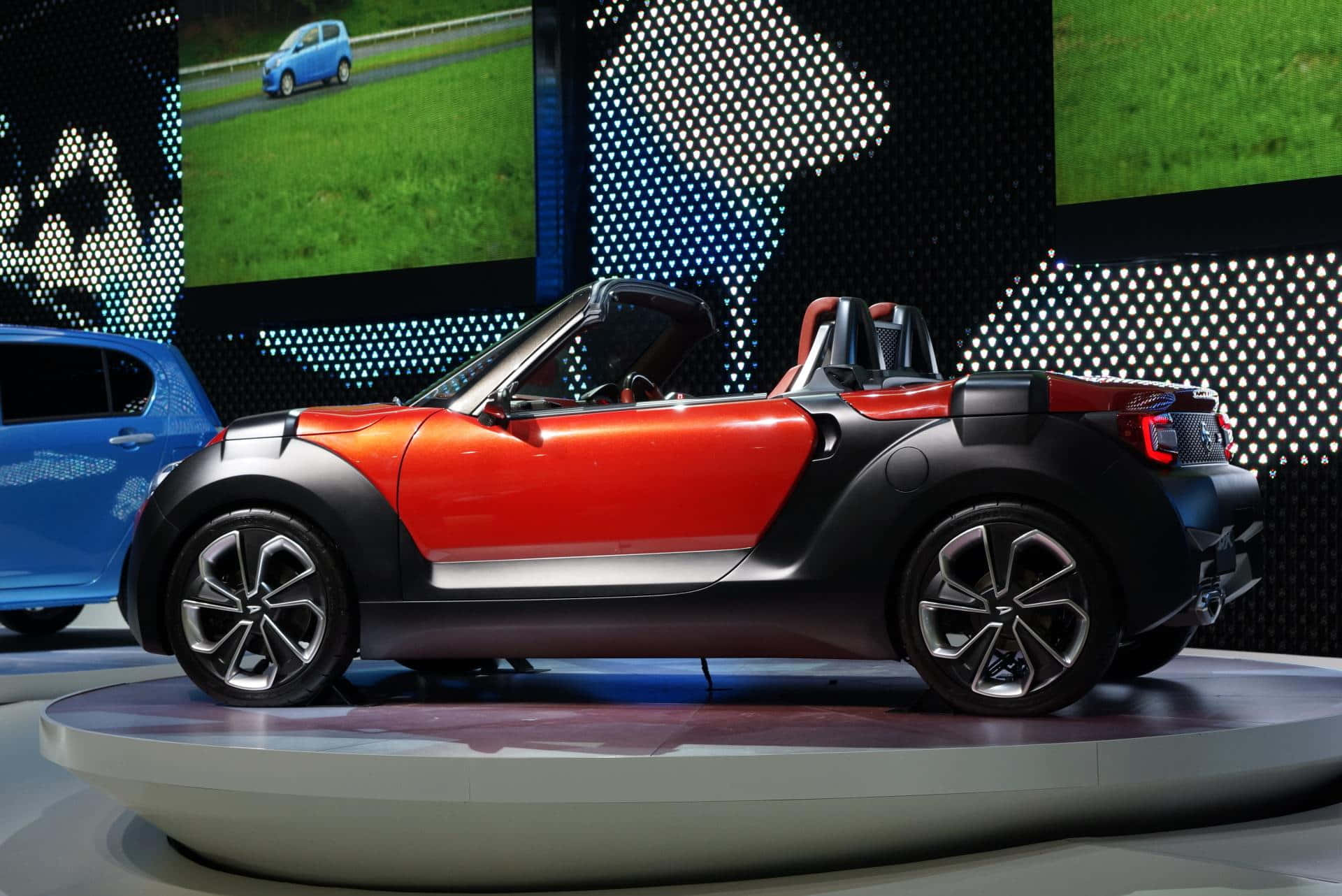 খোলা রাস্তায় চকচকে লাল Daihatsu ওয়ালপেপার