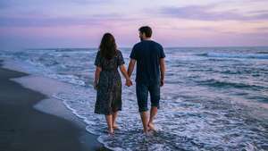 গোধূলি বেলায় সৈকতে হাঁটছে এক দম্পতি। — ভালোবাসা নান্দনিক ওয়ালপেপার
