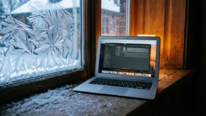 একটি MacBook Air তুষারময় জানালার সিলে আরামদায়ক অভ্যন্তরীণ আলো সহ। — ম্যাকবুক ওয়ালপেপার
